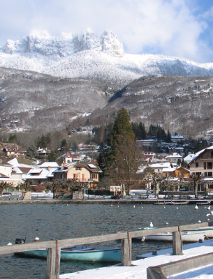 views of the snowy mountains from lake annecy