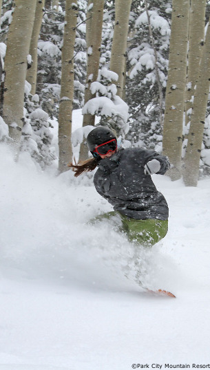 snow boarding in deep powder at park city ski resort